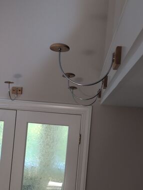 single hat wall display device. covered screws secure it to wall.